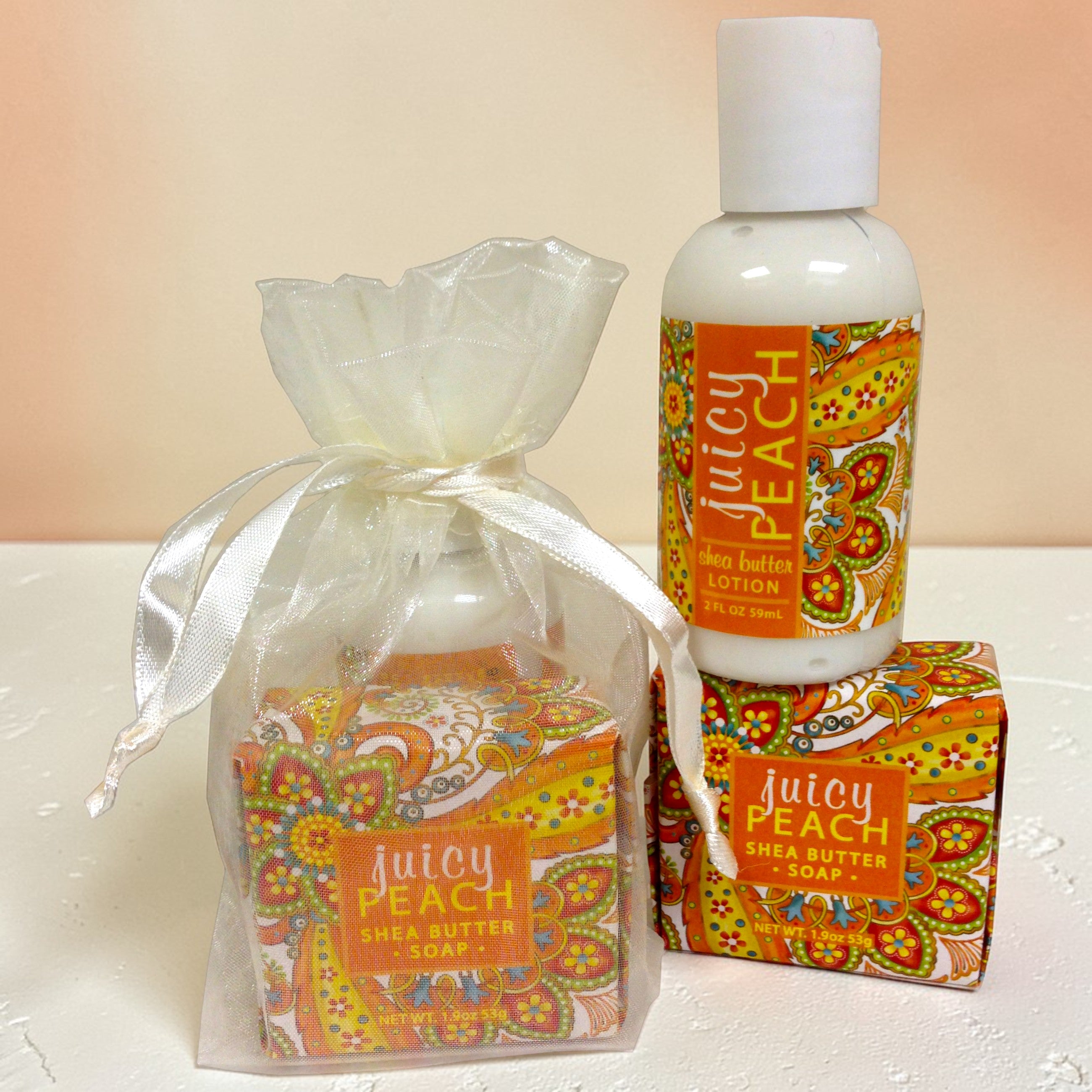 Juicy Peach shea butter products including soap, lotion, and packaging on a white surface.
