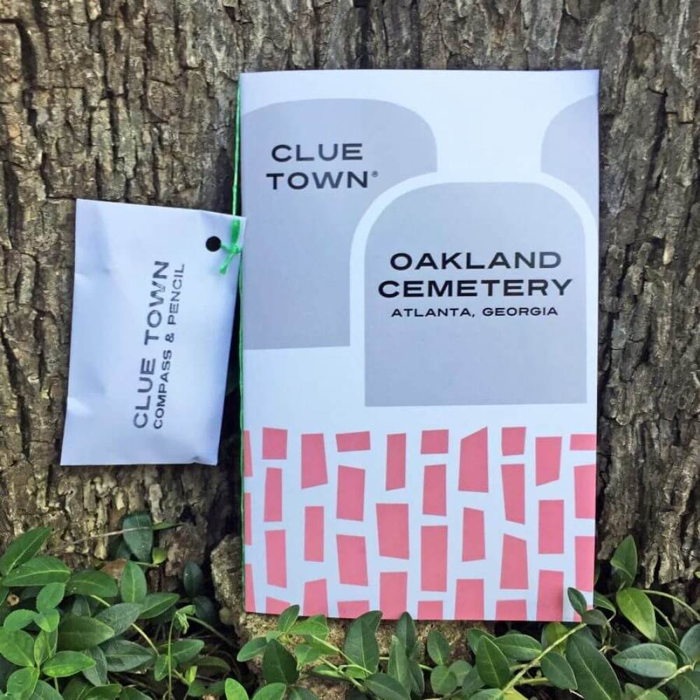 Paperback book for Oakland Cemetery features scavenger hunt, pen and compass to solve the clues inside.