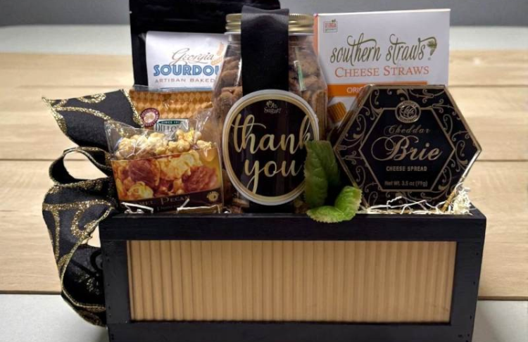 Gift basket with snacks and a 'thank you' cookie jar on a wooden surface