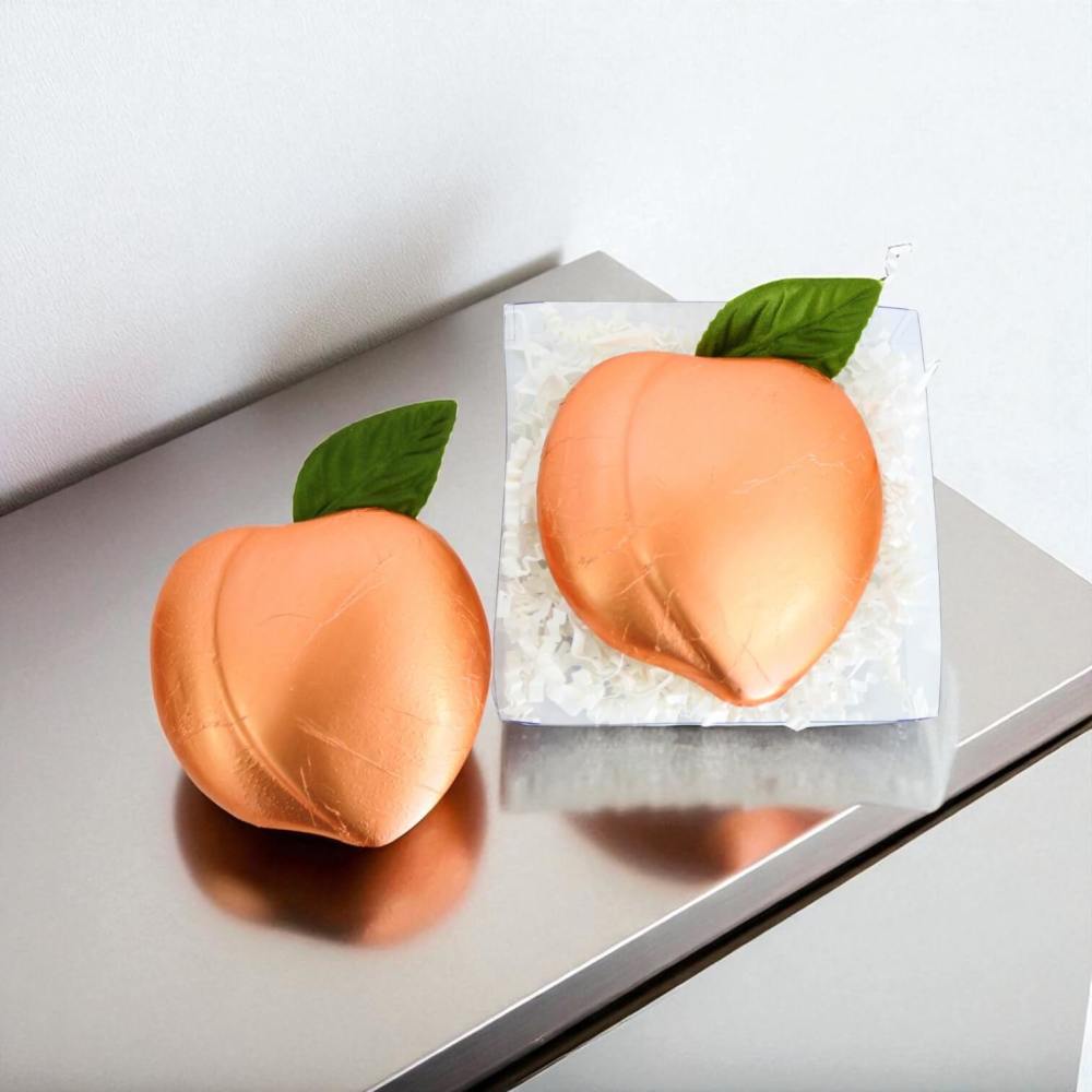 Foil wrapped peach shaped chocolate shown inside and outside of gift box