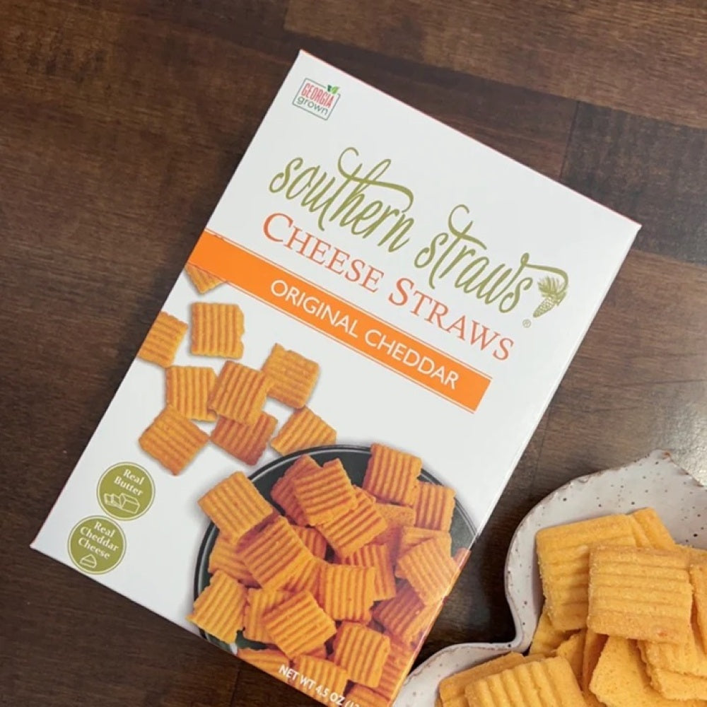 Box of Southern Straws Cheese Straws next to a few cheese straws on a plate