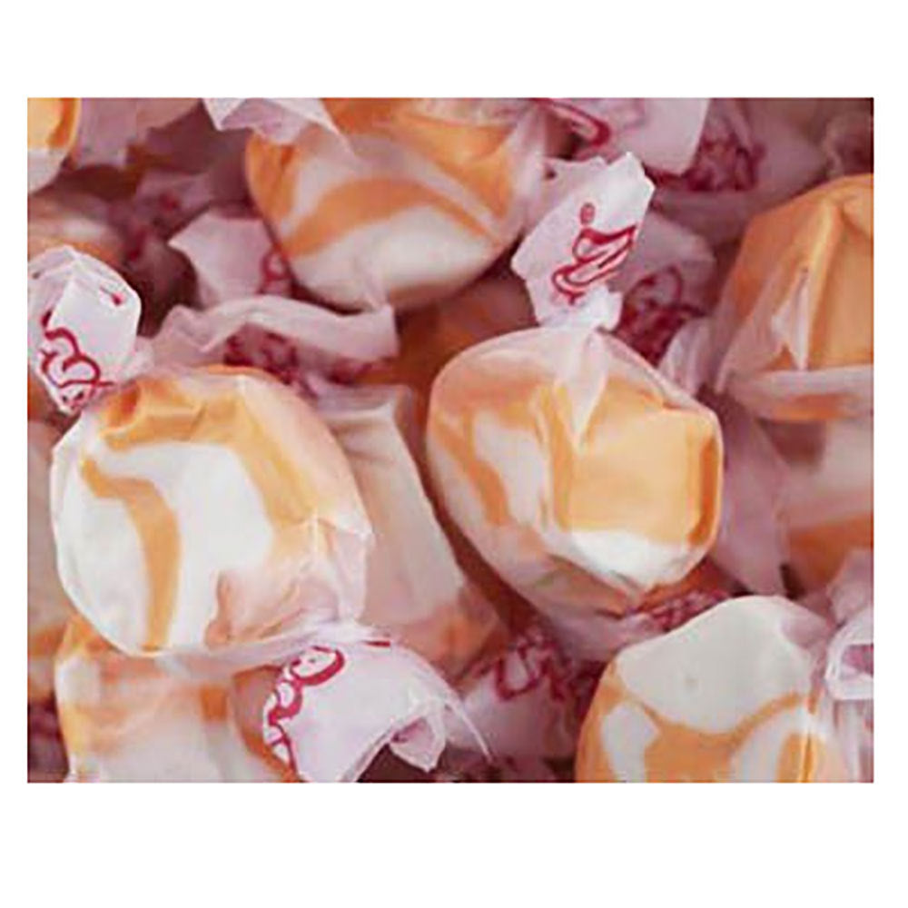Several pieces of individually wrapped Peach Taffy sold in bulk bags