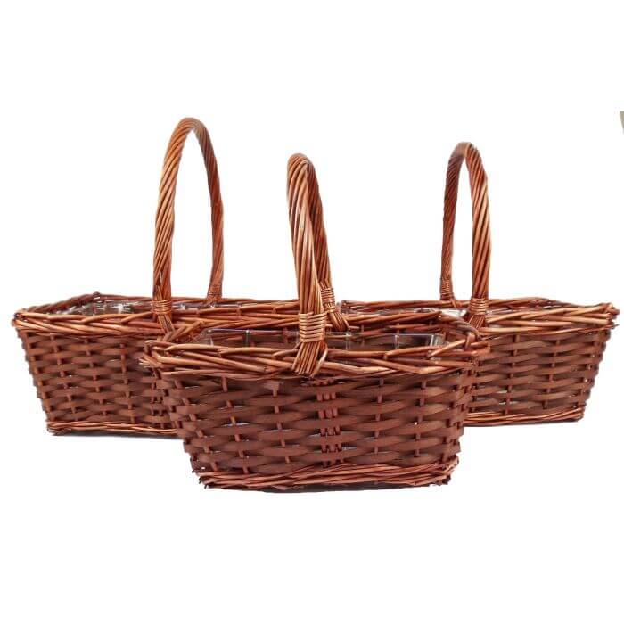 Three wicker baskets with handles on a white background