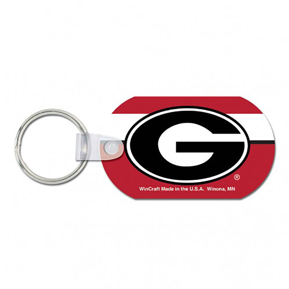 Oval metal Georgia Bulldogs key chain with big G logo on red and white striped background.