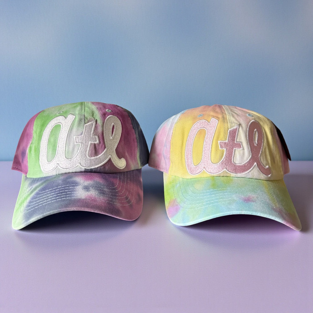 Two tie-dye baseball caps with &