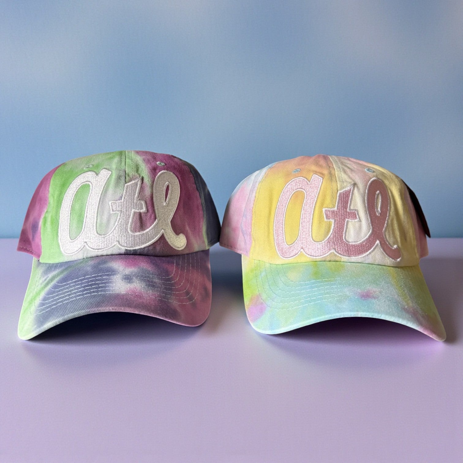 Two tie-dye baseball caps with &