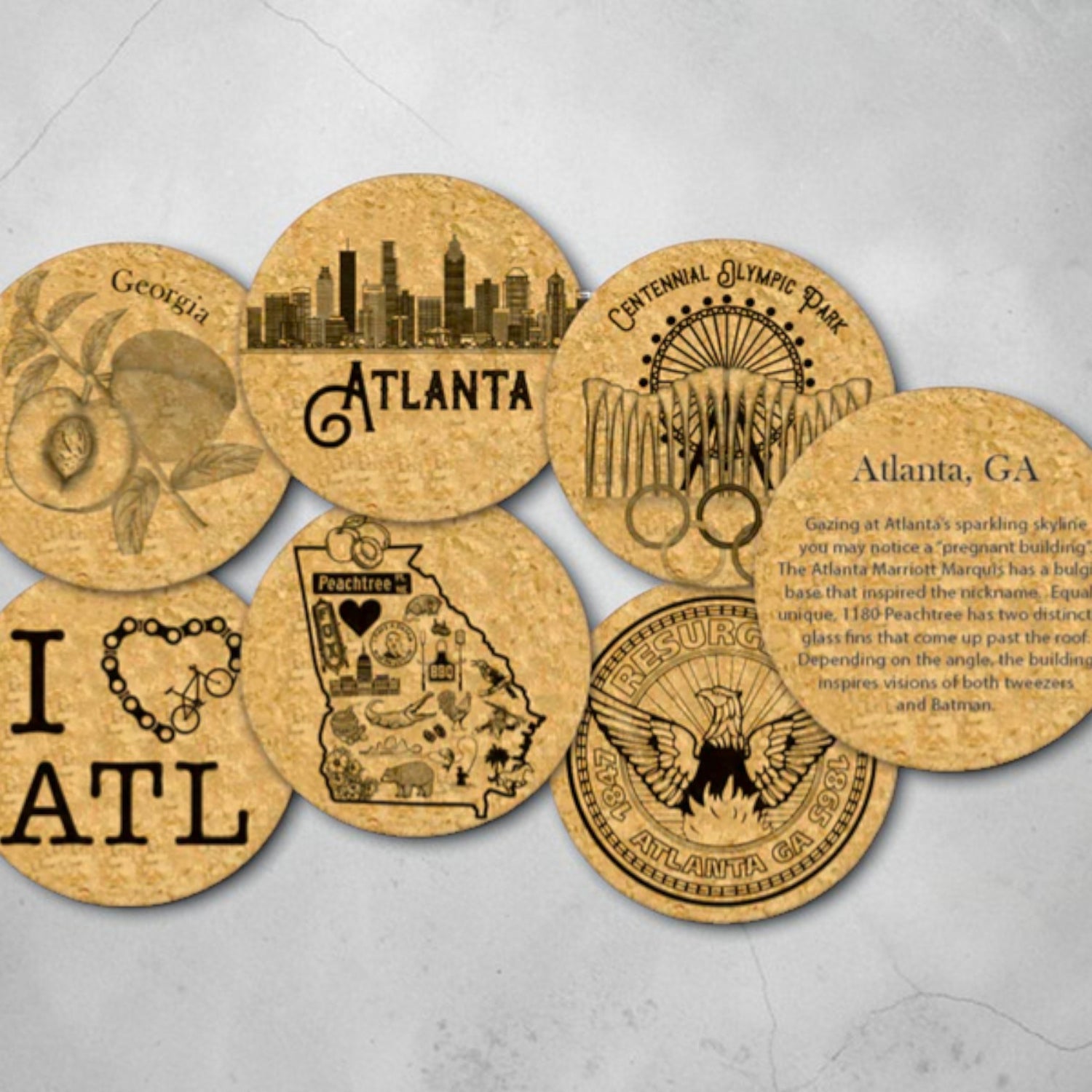 Set of cork coasters with various Atlanta-themed designs on a gray background