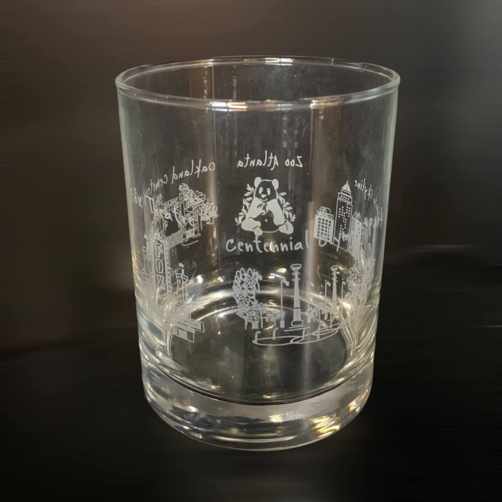 Clear beverage glass with Zoo Atlanta, Centennial Olympic Park, Fox Theatre and other Atlanta landmarks circling the glass