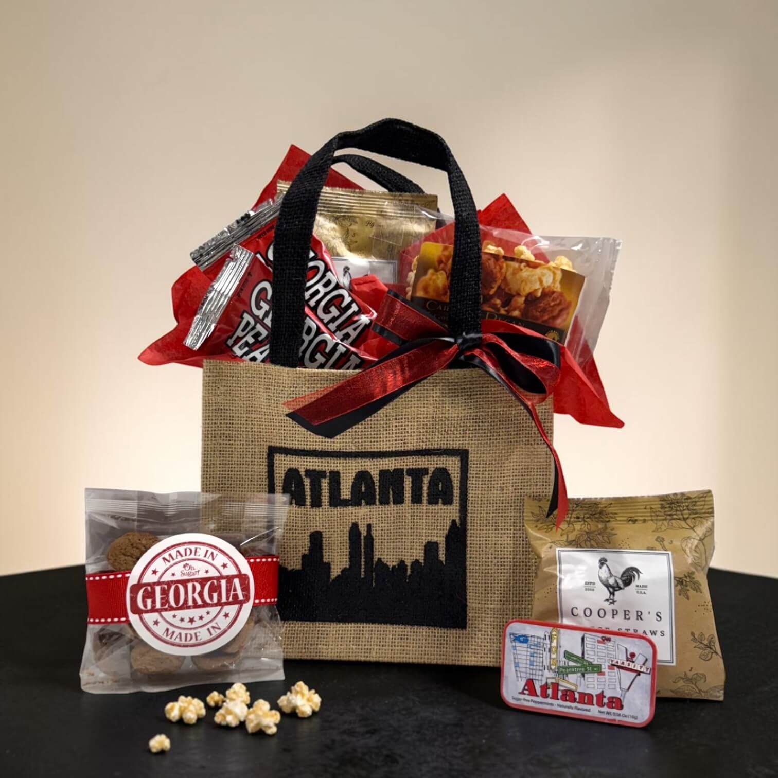 Atlanta burlap gift tote with Atlanta-themed items including popcorn and a small bag of cookies labeled &