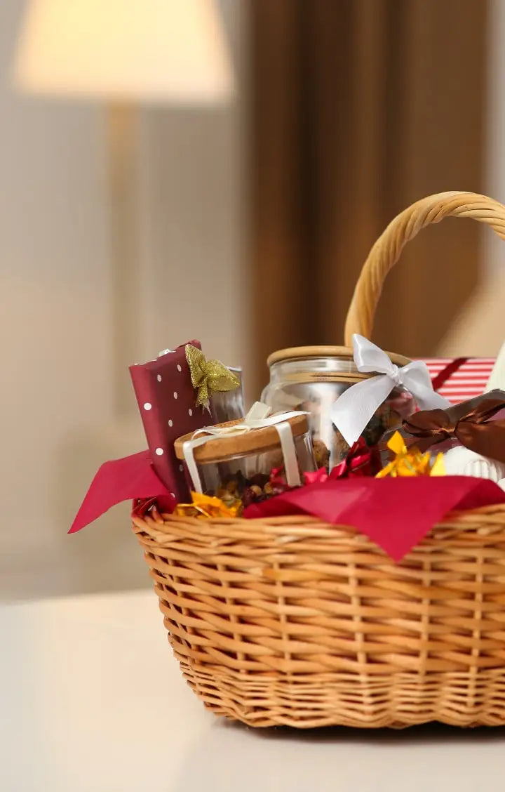 Wicker gift basket with a jar and red ribbon on a neutral background