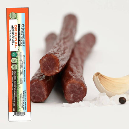 Three original beef sticks with a Thousand Hills packaging on a white background