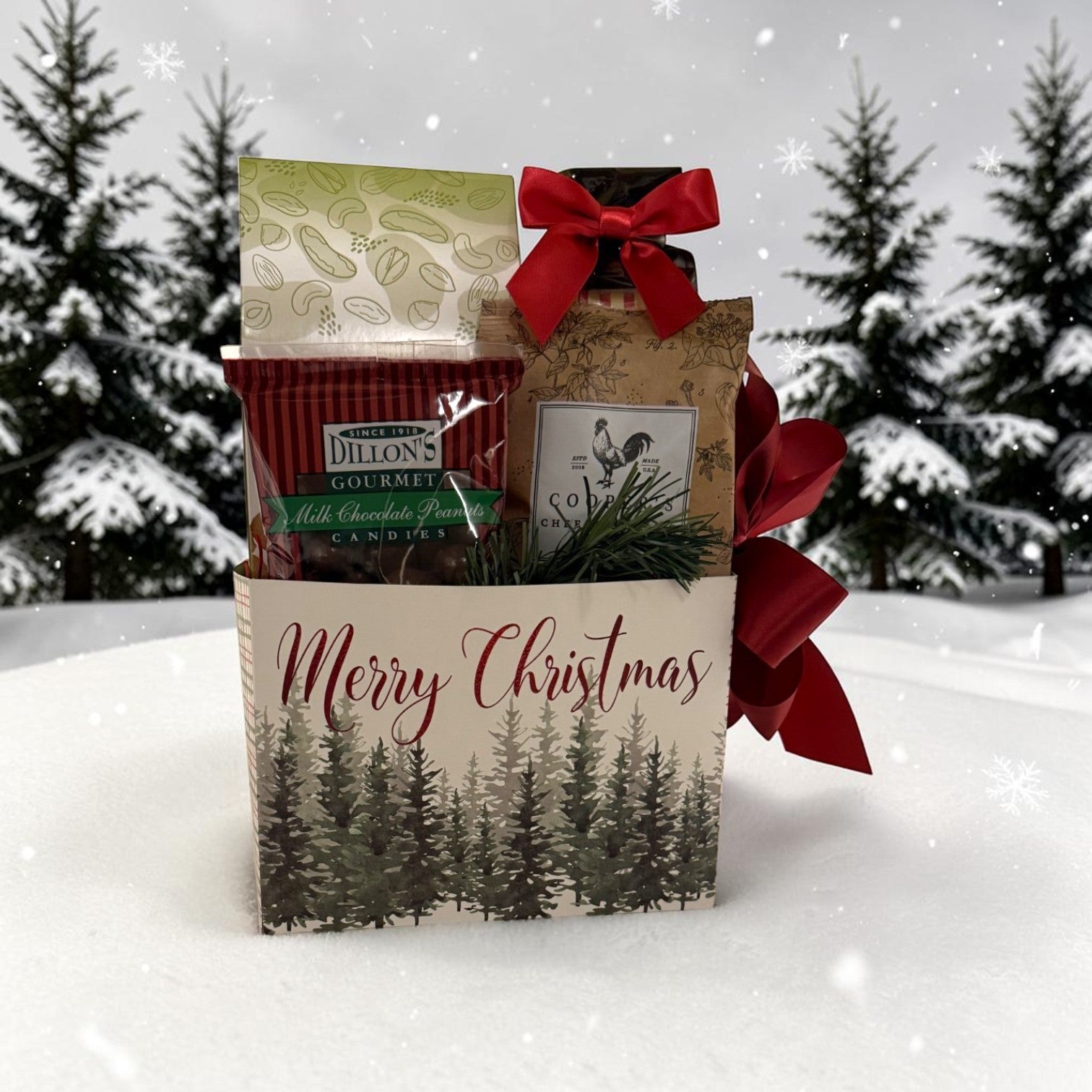 A Christmas-themed gift basket set in a snowy outdoor scene with pine trees in the background. The basket is decorated with a &