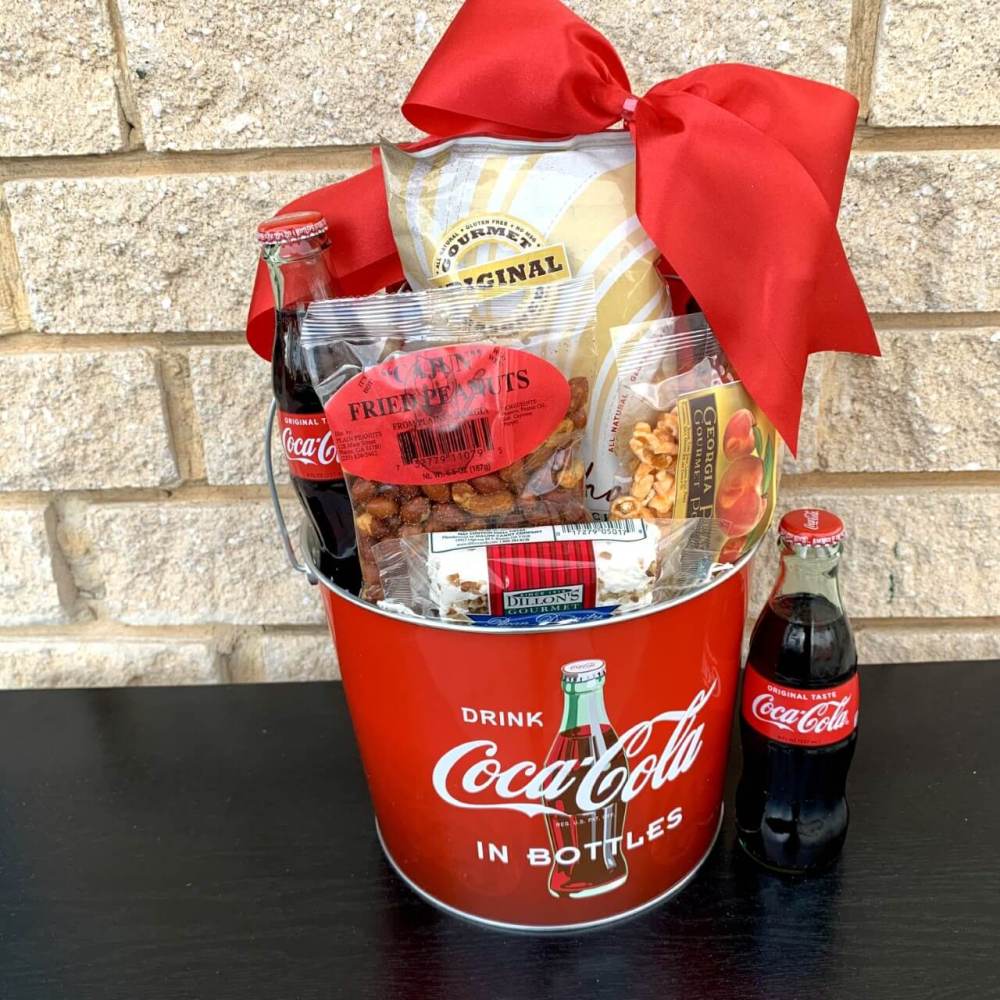Coke and a Smile Gift Basket includes pecan divinity, cajun fried peanuts,  Georgia peach popcorn , contour Coca Cola bottle and Symphony Gourmet chips 