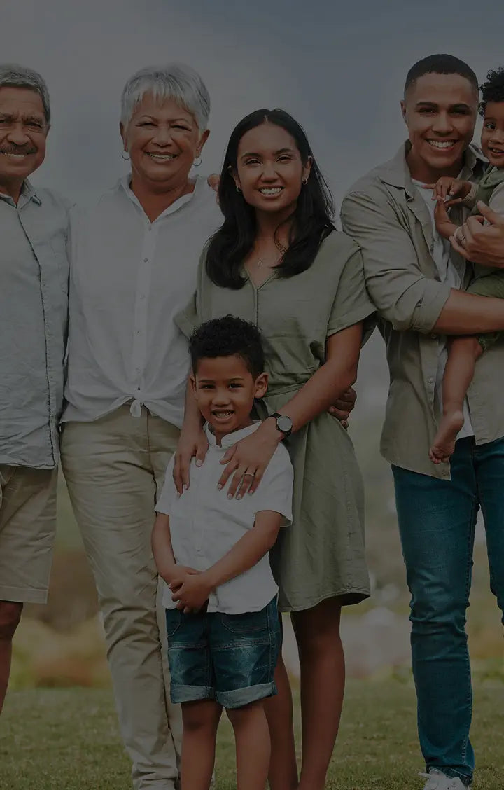 Family of six posing together outdoors with a blurred background