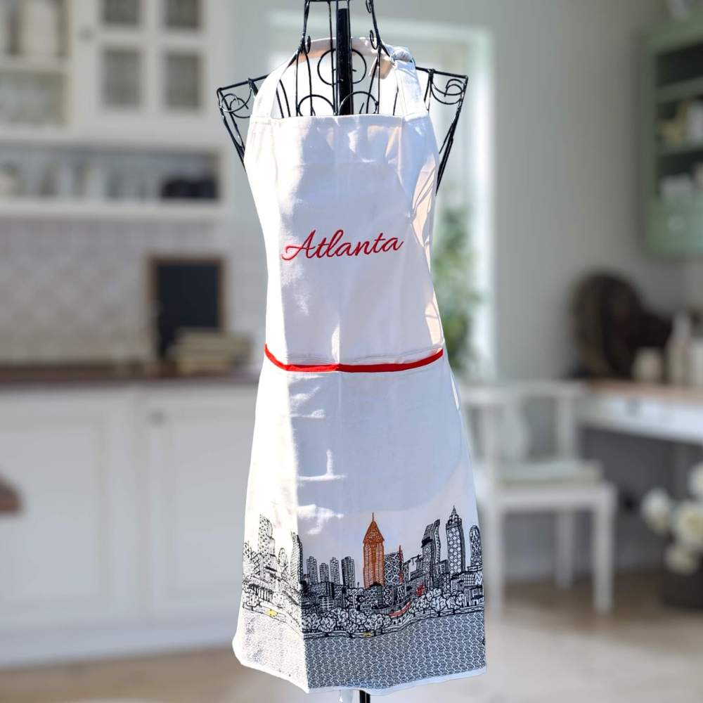 Cream colored Atlanta apron beautifully embroidered with the Atlanta skyline at the bottom and city name across the front.