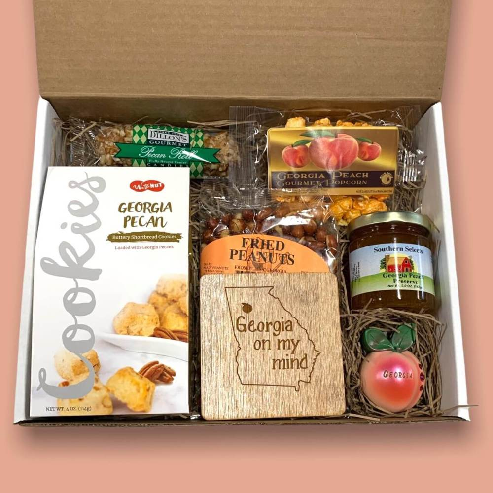 Inside layout of Georgia Gift box with Georgia-themed snacks and treats on a pink background