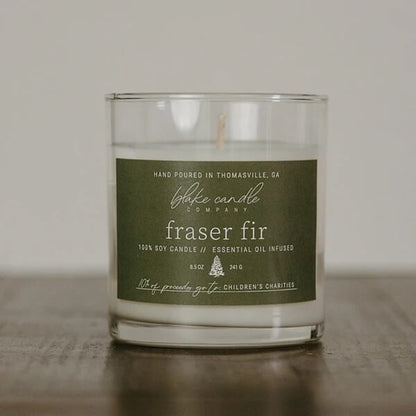 Fraser Fir Candle Jar with a green label on a wooden surface