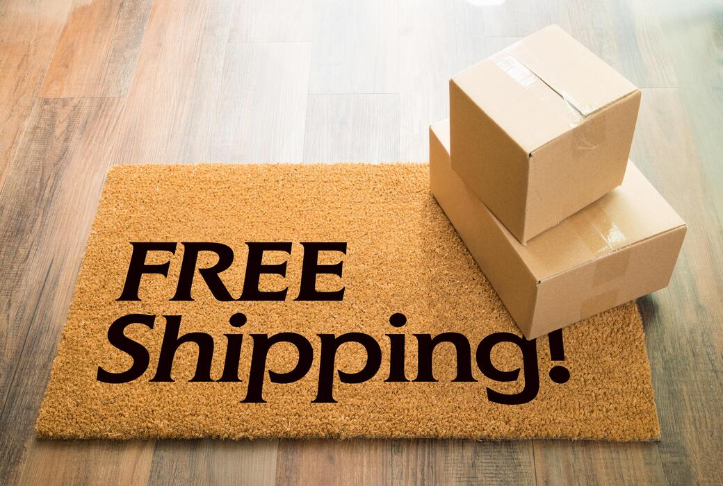 Two cardboard boxes stacked on a doormat with 'FREE Shipping!' text.