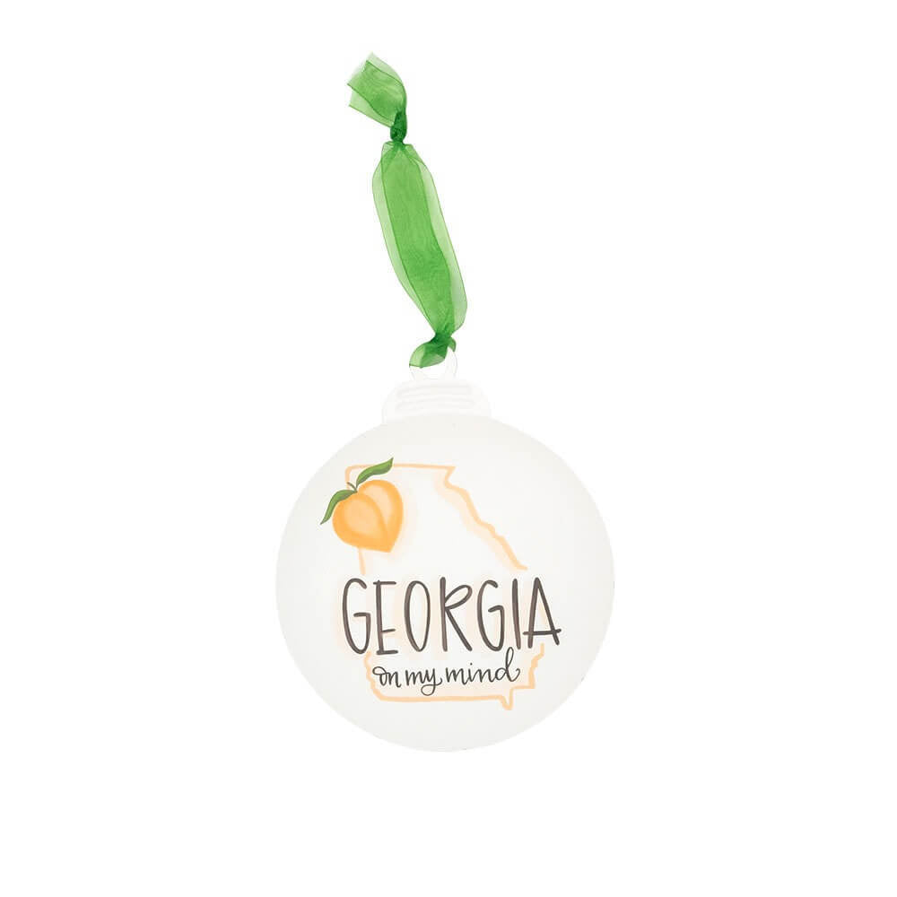Round metal ornament features the state of Georgia design that reads Georgia On My Mind