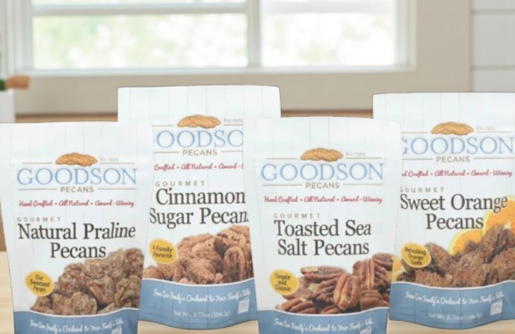 Four packages of Goodson Pecans with different flavors on a table.
