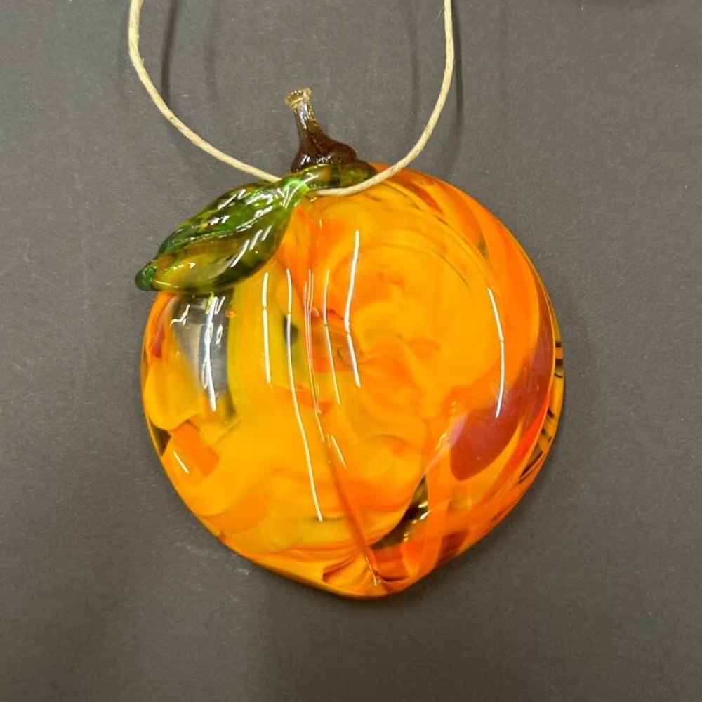 Handmade elegant glass peach with swirls of vibrant color inside the glass.