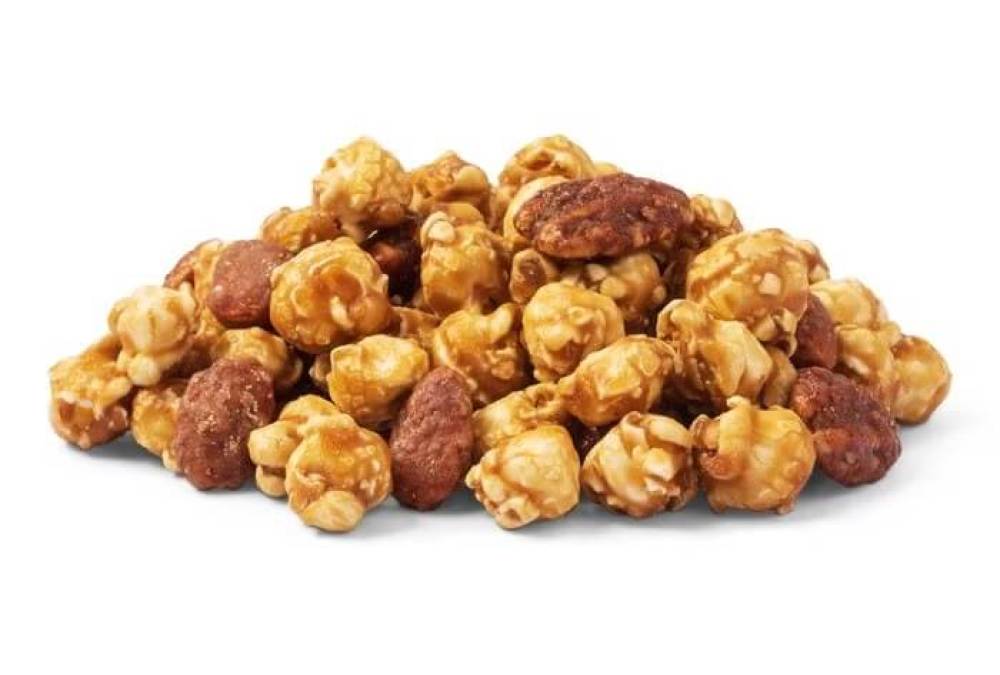Pile of caramel corn and Georgia nuts on a white background