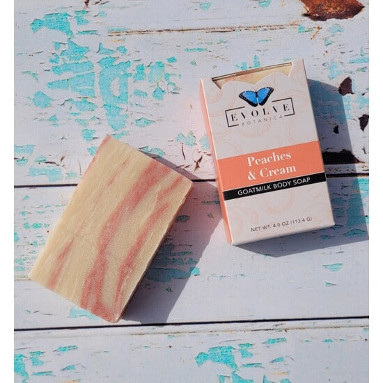 Peaches and Cream Goatmilk body soap with packaging on a rustic wooden surface