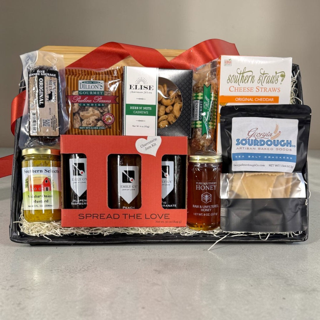 Charcuterie theme gift basket with various food items on a gray surface