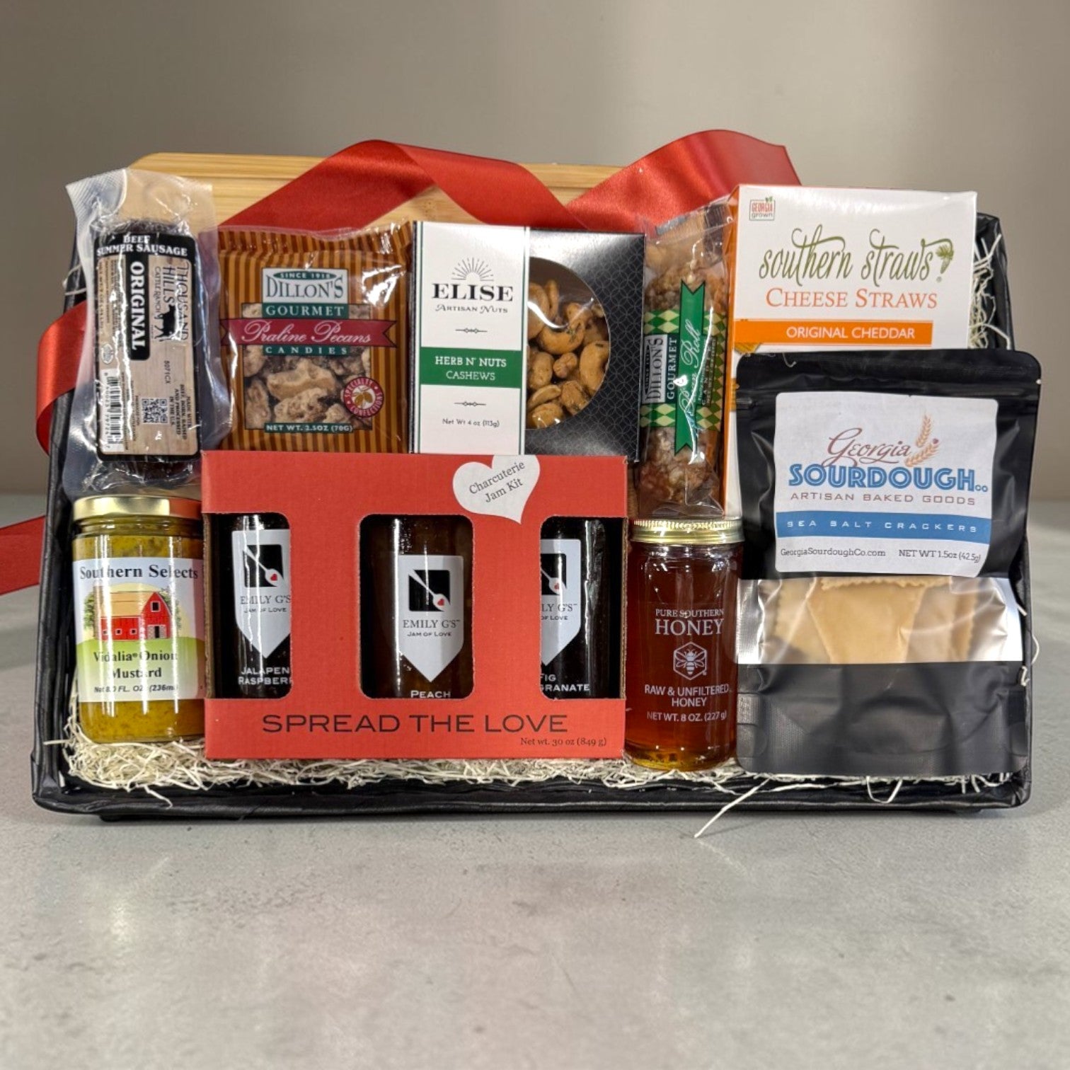 Charcuterie theme gift basket with various food items on a gray surface