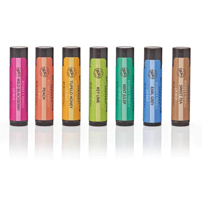 Set of seven Savannah Bee lip balms with colorful packaging on a white background