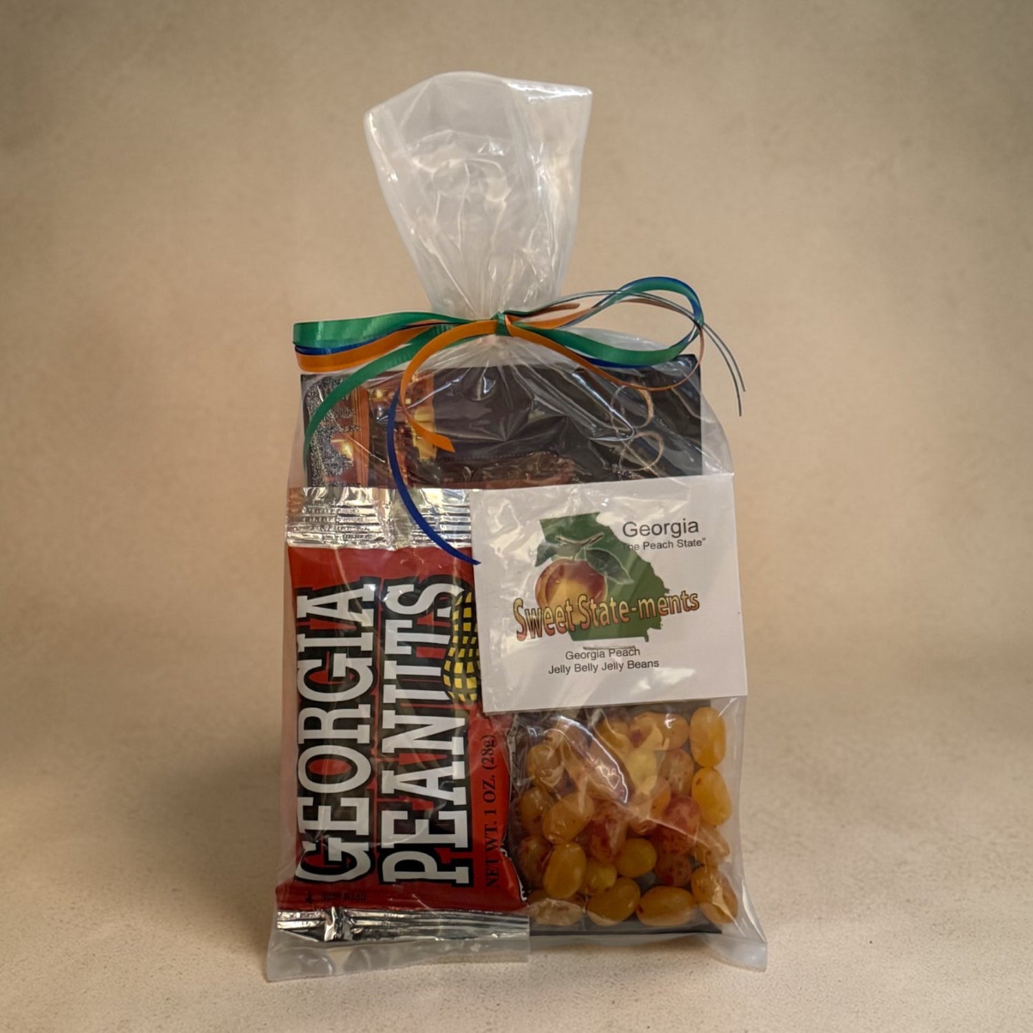 Gift bag with Georgia Peanuts, Jelly Beans, and postcard on a beige background
