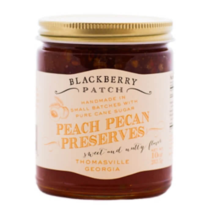 Jar of Blackberry Patch Peach Pecan Preserves with a gold lid on a white background