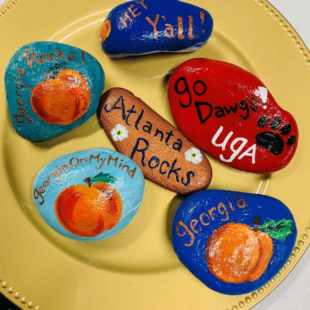 Hand painted rock art with different Georgia icons and slogans