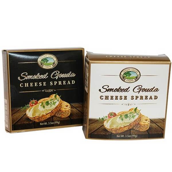 Two boxes of Smoked Gouda Cheese Spread with a brand logo on a white background, one black, one white