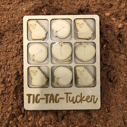 Tic-Tac-Toe game set with Georgia and peach designs for Tucker on a brown surface
