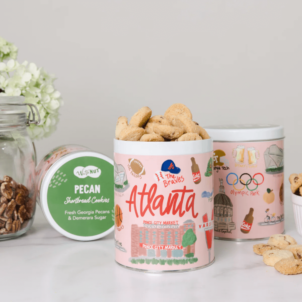 Round tin filled with Georgia pecan shortbread cookies features Atlanta landmarks artwork around the tin.