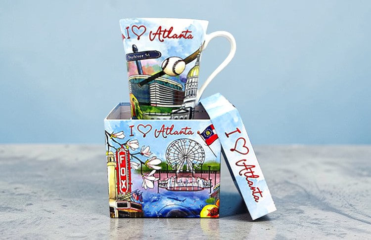 Mug with 'I ❤️ Atlanta' design, placed inside a box with similar design, on a light blue background.