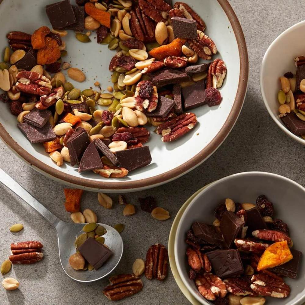 Bowl of trail mix with Georgia pecans, peanuts, dried peaches and cranberries.