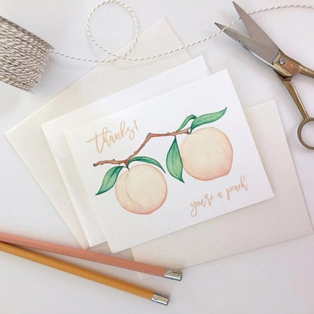 Peach theme thank you note card surrounded by office related items
