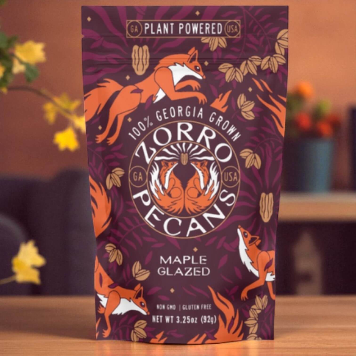 Zorro Pecans maple glazed pecans packaging with fox illustrations on a wooden surface.